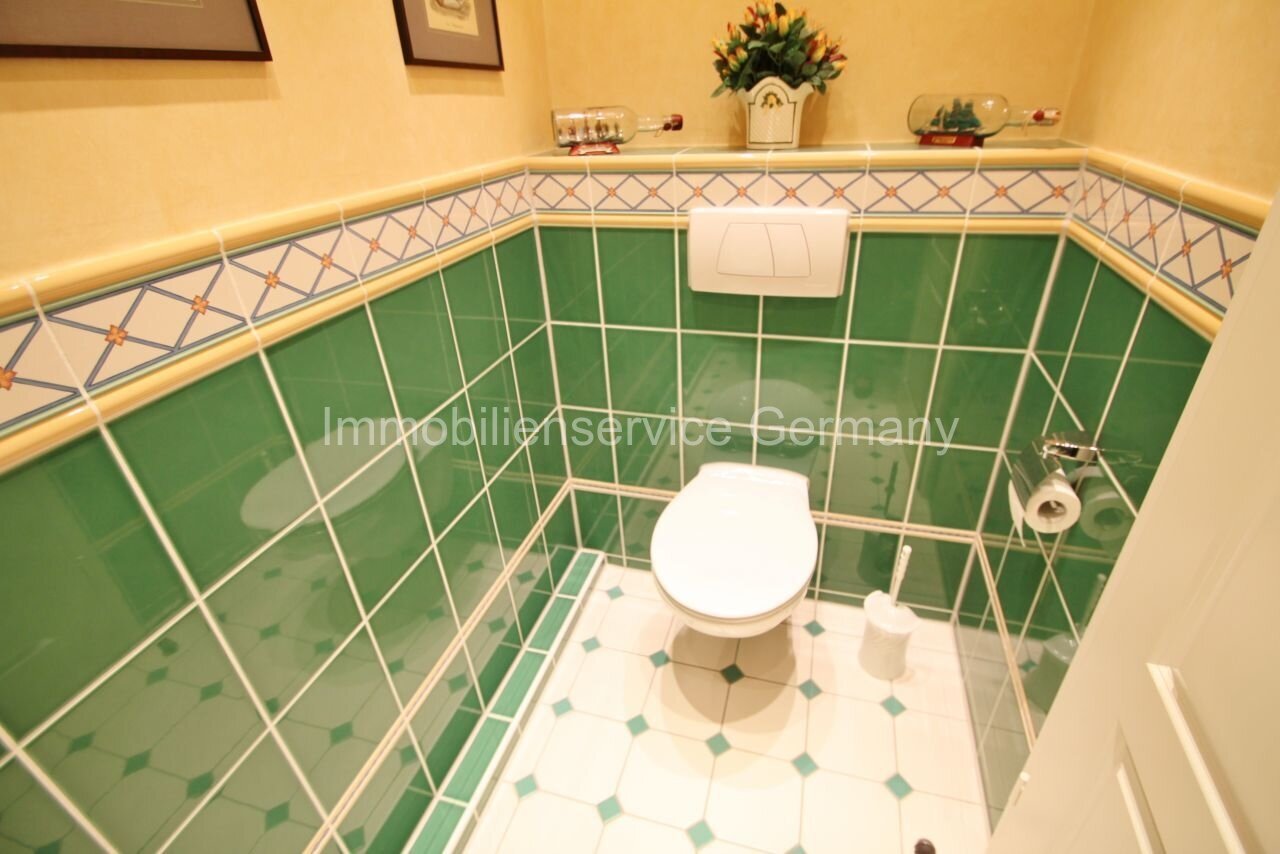 Gäste-WC mit eleganter Grünkachel-Optik und stilvollem Zierband - Ihr neues Wohlfühl-Ambiente!