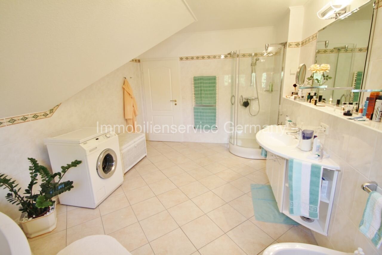 Oasis de confort bajo el tejado: baño moderno con ducha, estación de lavado integrada y uso inteligente del espacio