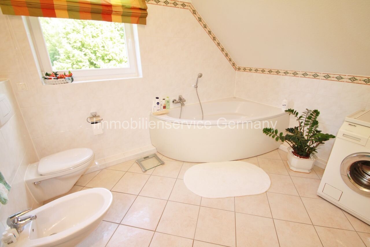 Oasi di benessere sotto il tetto: bagno spazioso con vasca rotonda e ambiente con luce naturale